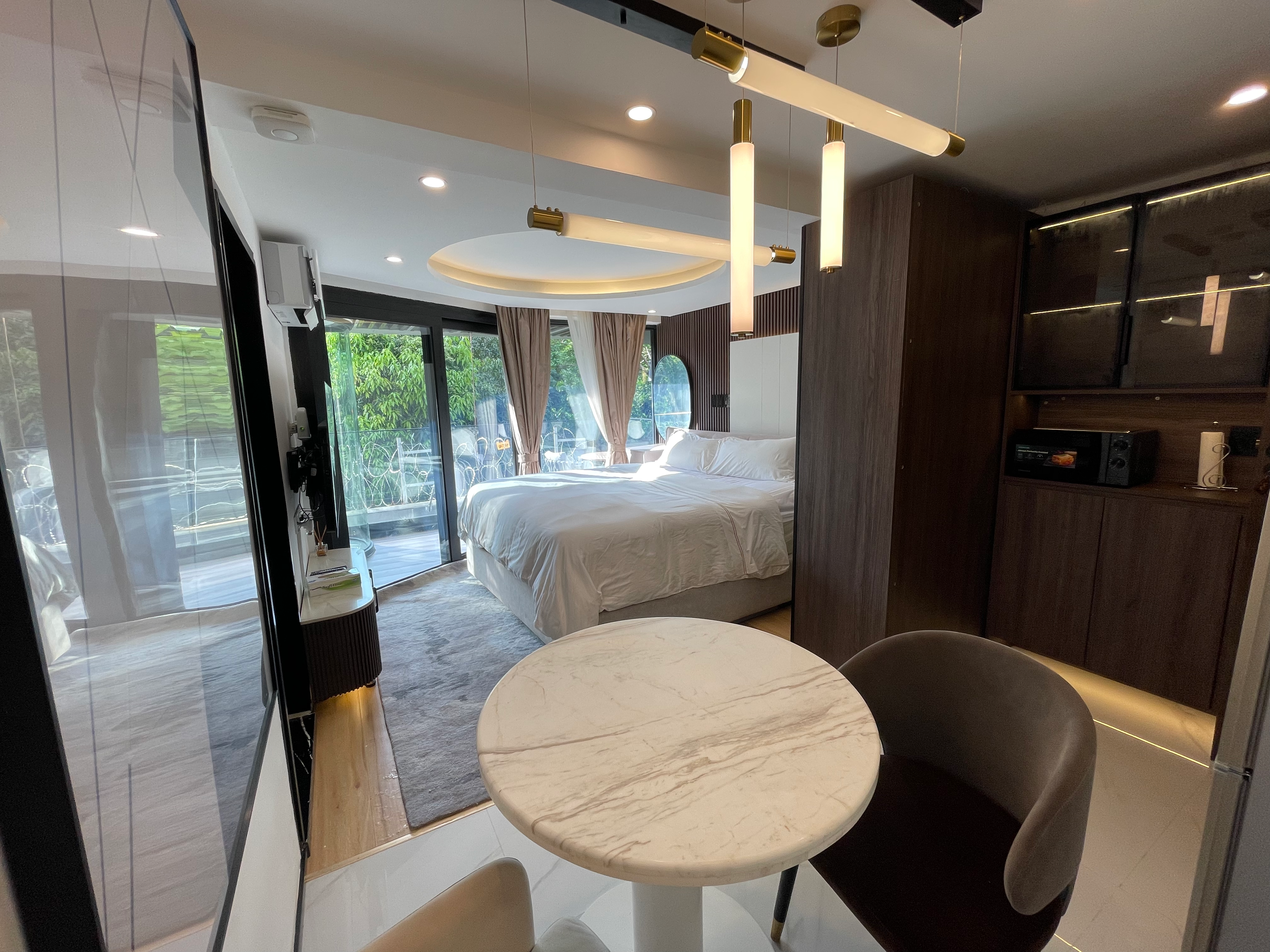 Designer suite with floor-to-ceiling windows and forest view from king bed