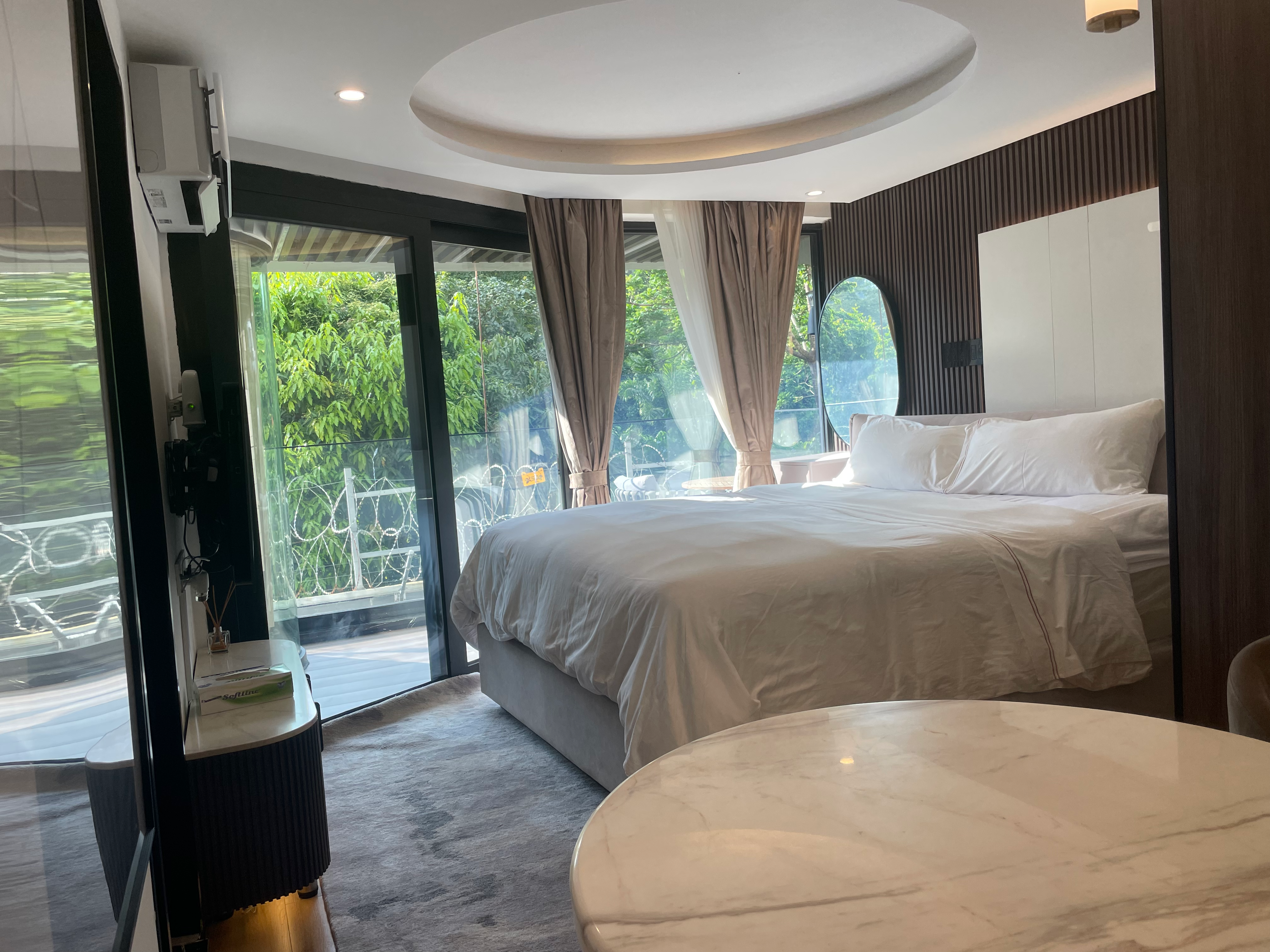 Bedroom with natural daylight streaming through floor-to-ceiling windows