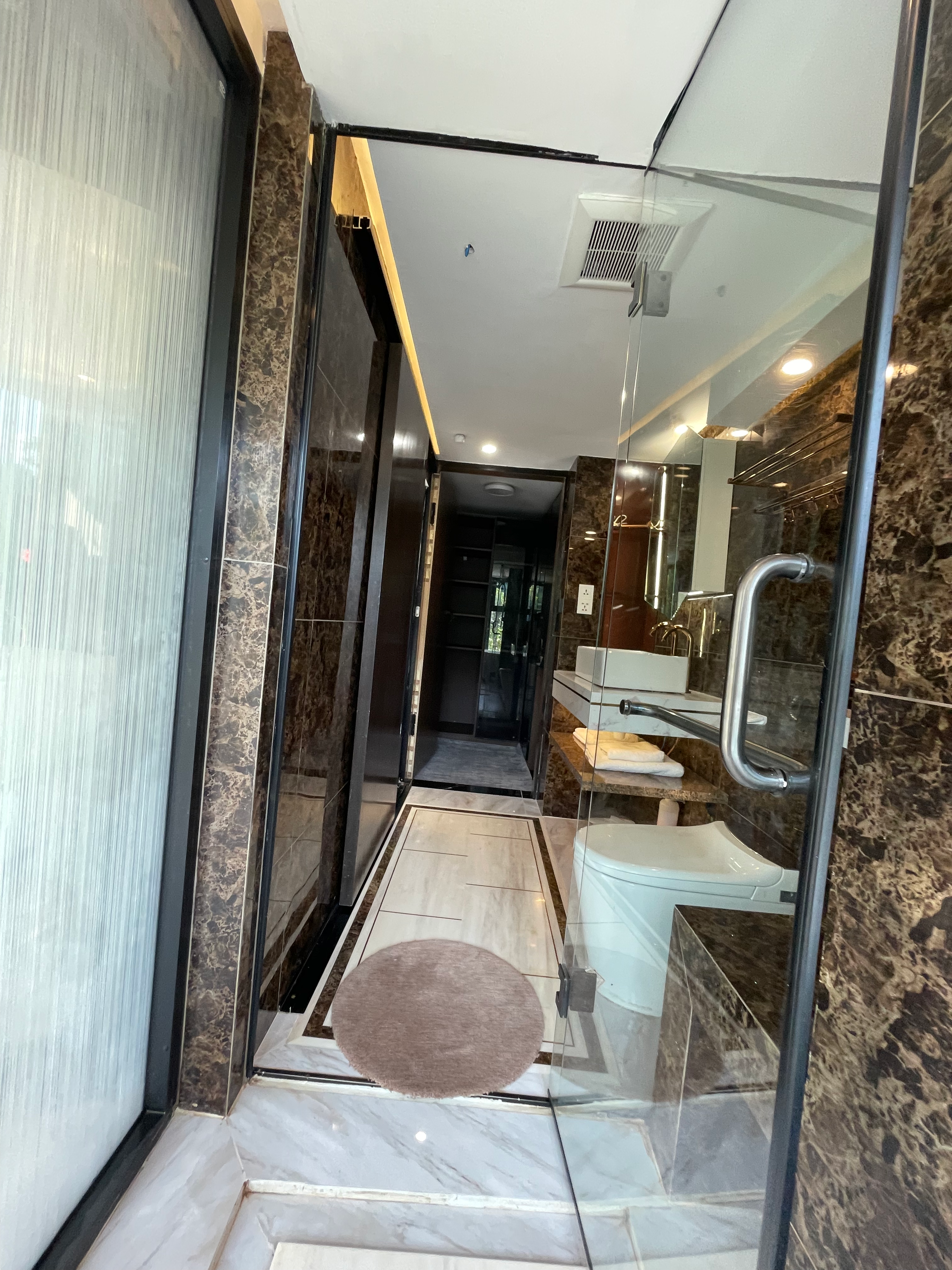 Floor-to-ceiling dark marble bathroom interior